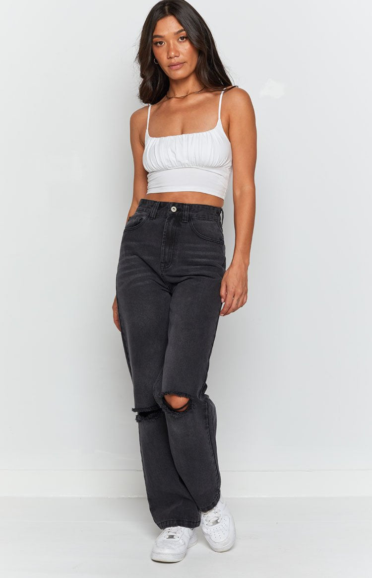 Black wash jeans with a horizontal rip detail and frayed edges on the knee