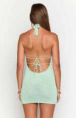 Back view of a light green knit mini dress showing the halter neck tie and low back with horizontal tie straps