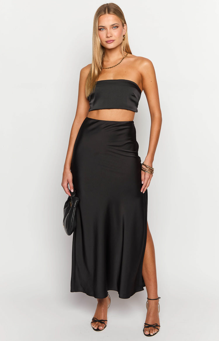 Front view of the black satin maxi skirt showing its full length, flowy drape, and high side slit