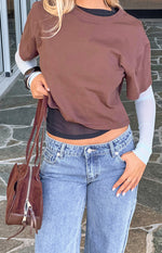 Close-up of the brown short sleeve top layered over a black mesh crop top and light blue long sleeve top