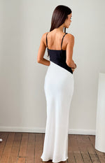 Rear view of a black and white satin maxi dress with thin adjustable spaghetti straps and a diagonal colour block design