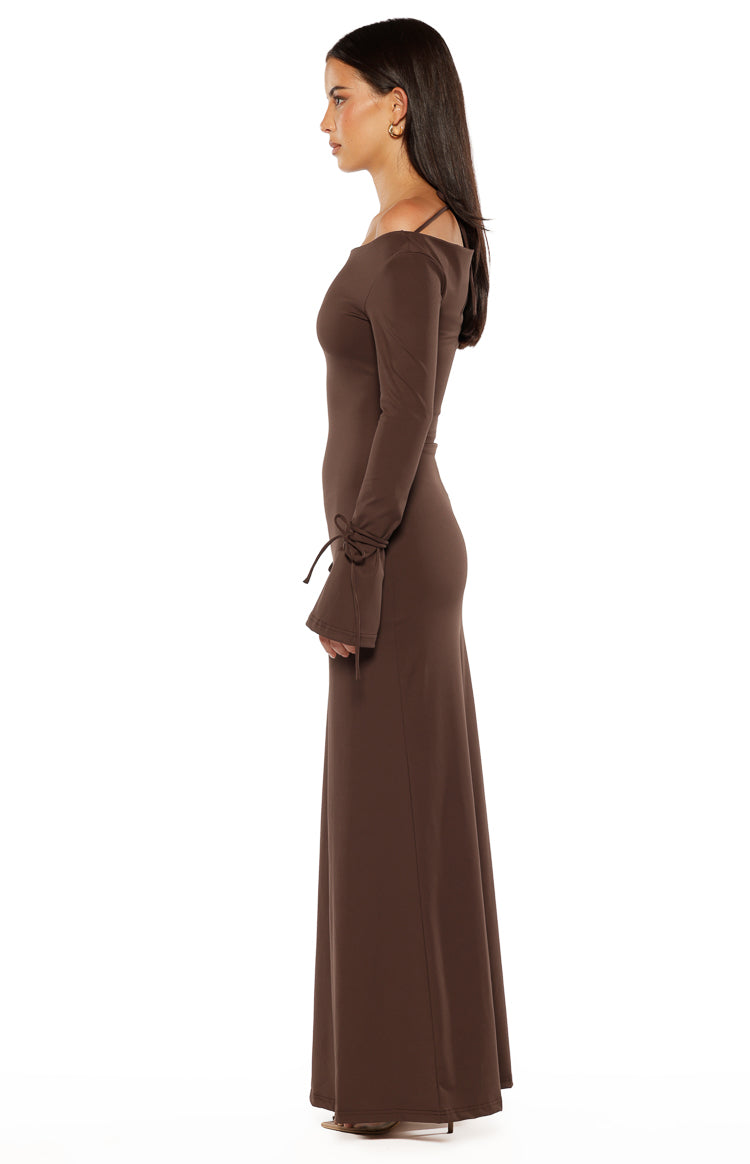 Side view of a chocolate jersey maxi dress with an off-shoulder neckline and long sleeves with tie cuffs