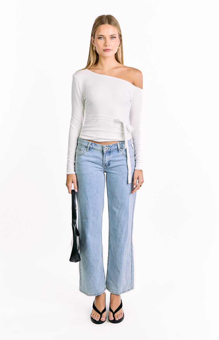 White long sleeve top with an off-the-shoulder neckline and tie waist detail, showing its cropped fit