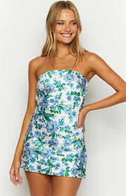 Close-up of the white strapless mini dress with a vibrant blue and green floral pattern