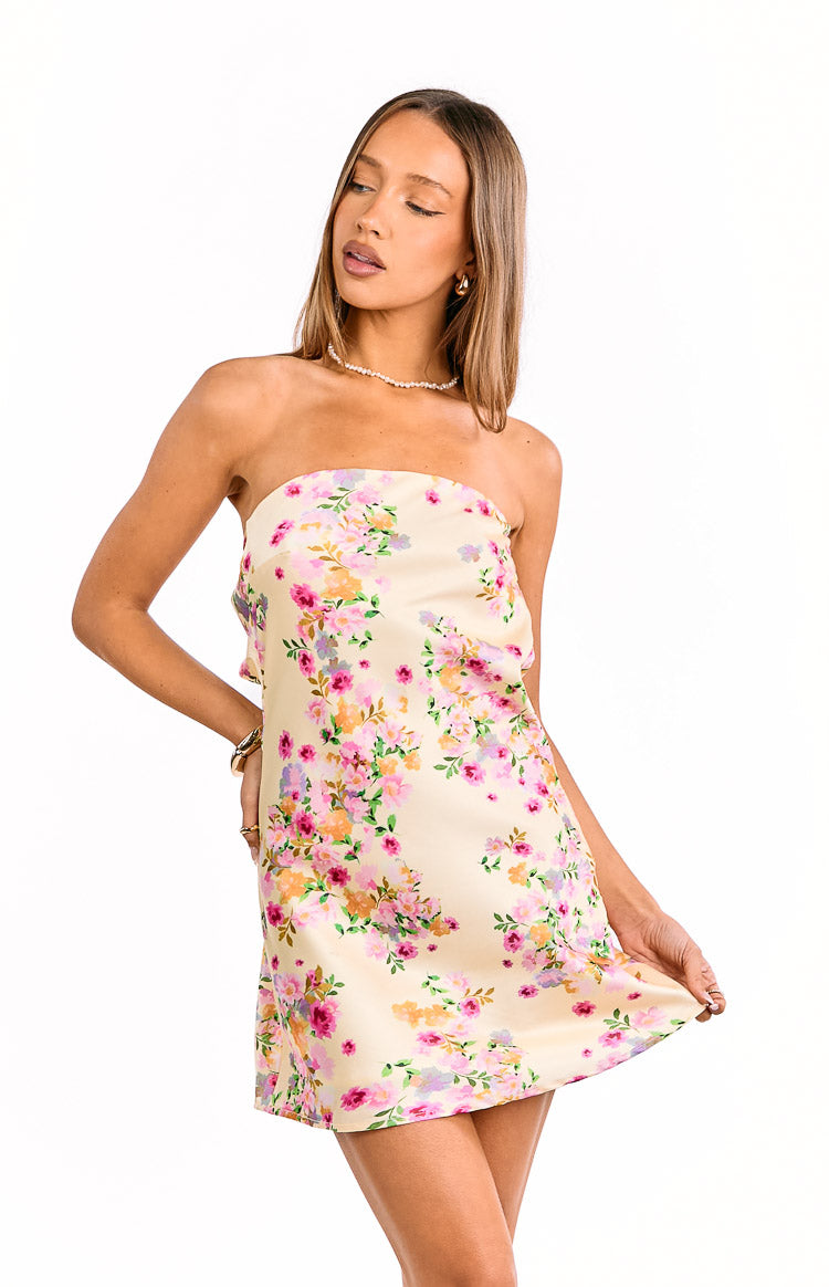 Front view of a pale yellow strapless mini dress featuring a vibrant pink and orange floral print