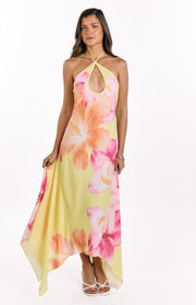 Front view of a yellow hibiscus floral halter maxi dress with keyhole cutout and flowy handkerchief hem
