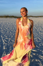 Yellow hibiscus floral halter maxi dress with a flowy skirt, highlighting the fabric's soft drape