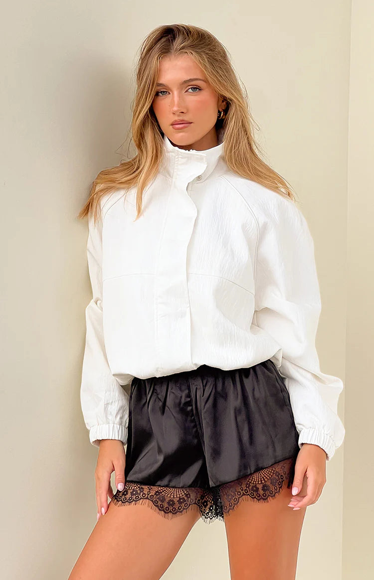 Front view of a cream funnel neck sports jacket, worn open, showing the relaxed fit and elasticated cuffs