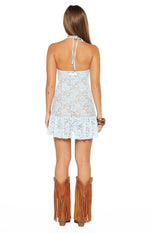 Rear view of the light blue sheer lace mini dress with halter neck ties and a ruffled hem