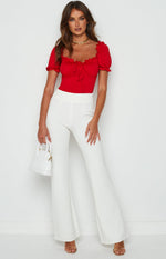 White high-waisted wide-leg pants with a smooth tailored finish and a subtle side zipper closure
