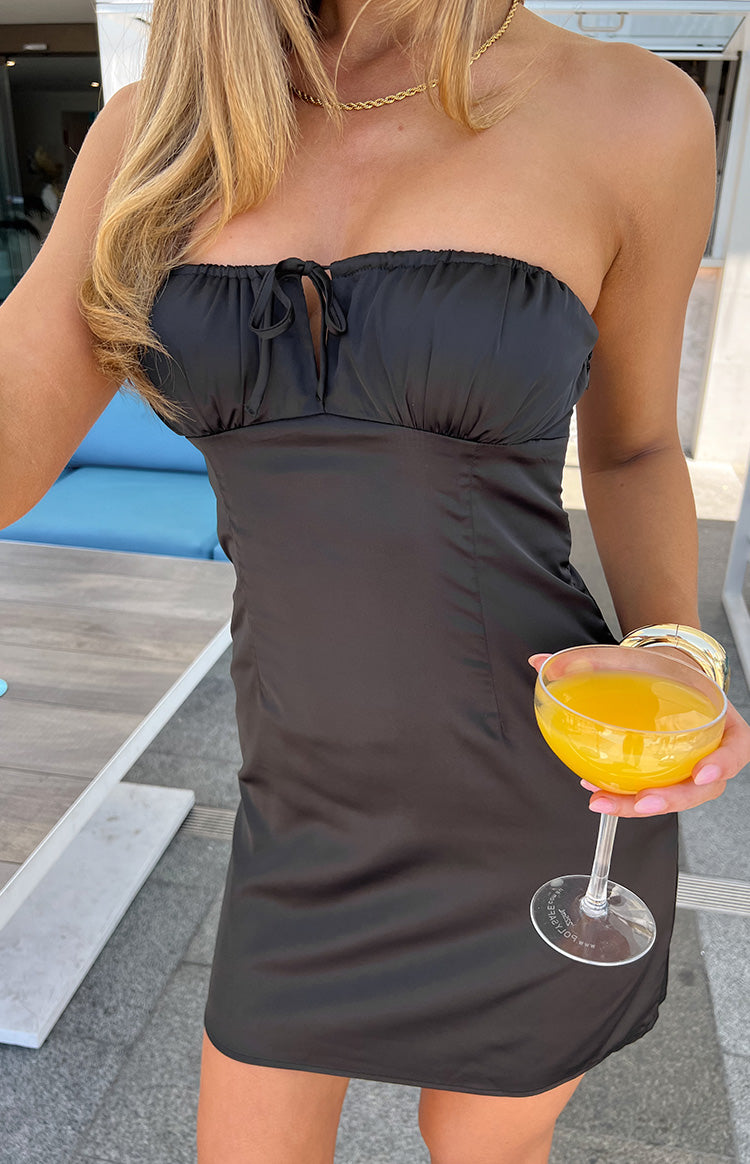 Close-up of the black satin strapless mini dress with a tie-front ruched bust detail