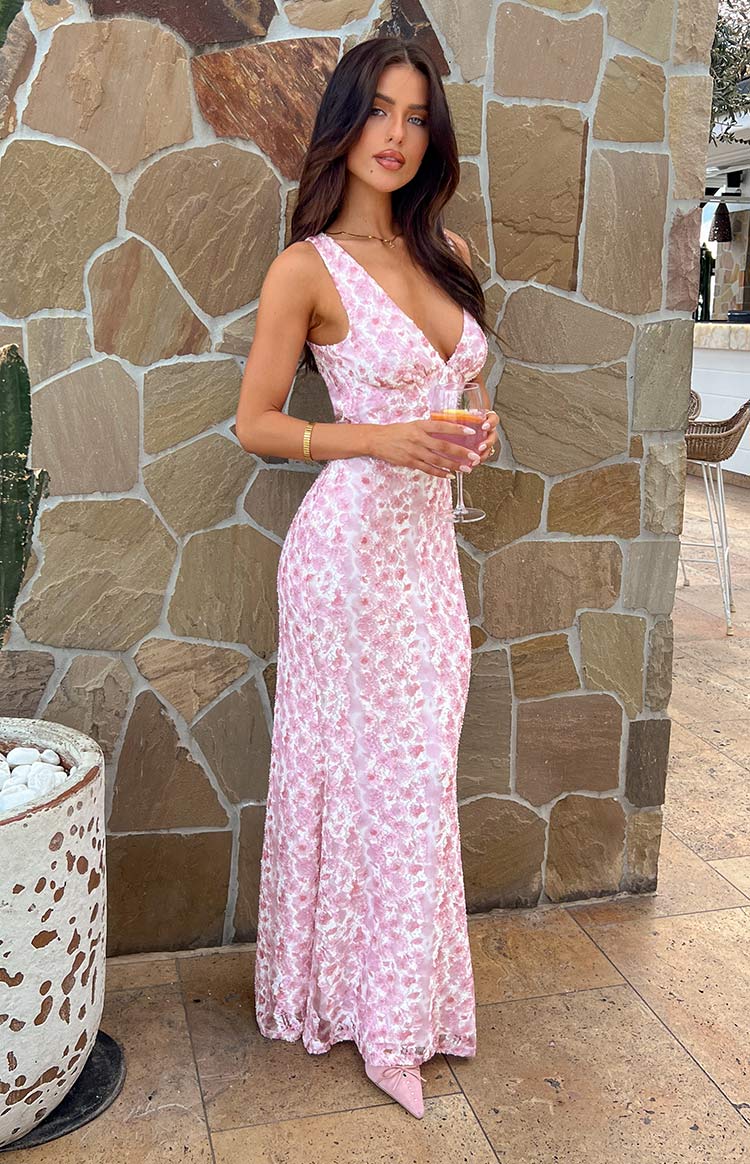 Pink floral lace maxi dress with a V-neckline, thin straps, and a fitted silhouette flowing to the floor