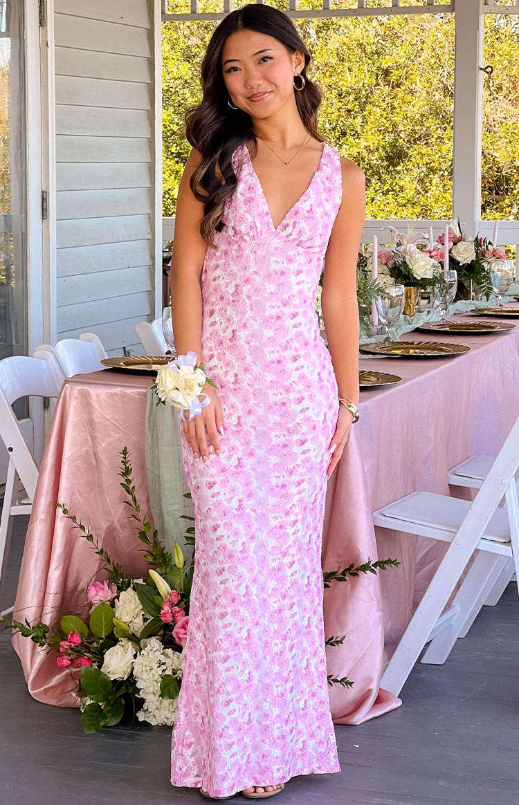 Front view of a pink floral lace maxi dress with a deep V-neckline and fitted silhouette