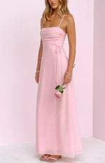 Rear-side view of a pink maxi dress showing thin spaghetti straps, a low back, invisible zipper, and side ruching