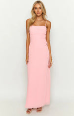 Full length view of a pink maxi dress with a ruched bust, thin spaghetti straps, and side tie details