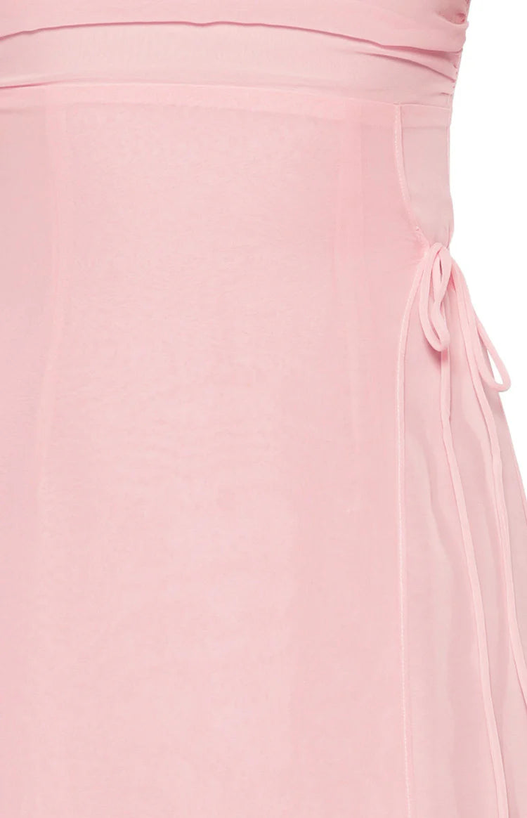 Close-up of the sheer pink fabric and delicate side tie detail on the maxi dress