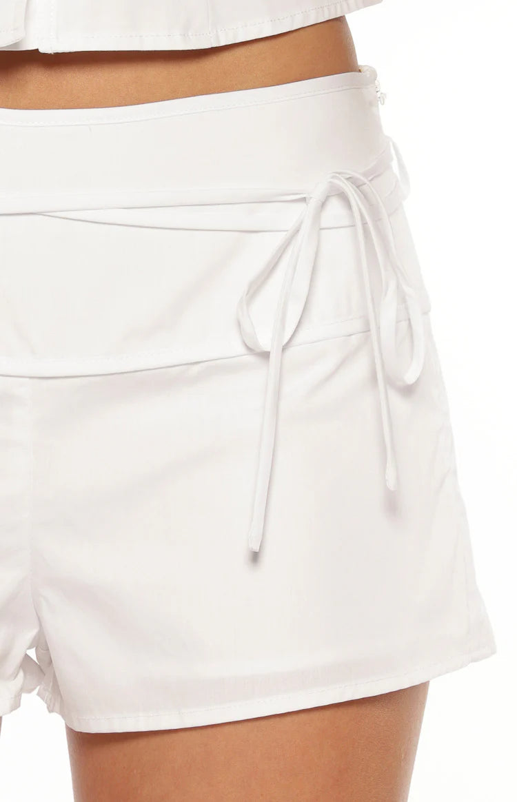Front view of white fitted high-waisted mini shorts in a smooth cotton blend fabric for casual wear