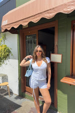 White relaxed fit shorts with long drawstring ties on the sides