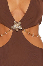 Close-up of the brown mini dress showing the gold flower detail with beaded chains and side cutouts