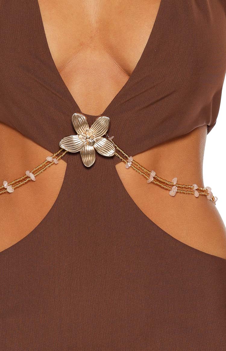 Close-up of the brown mini dress showing the gold flower detail with beaded chains and side cutouts