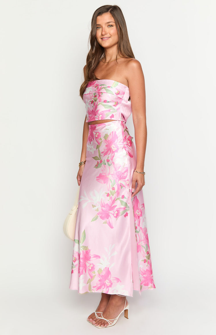 Side view of a pink floral print strapless cropped top with a bow detail at the back
