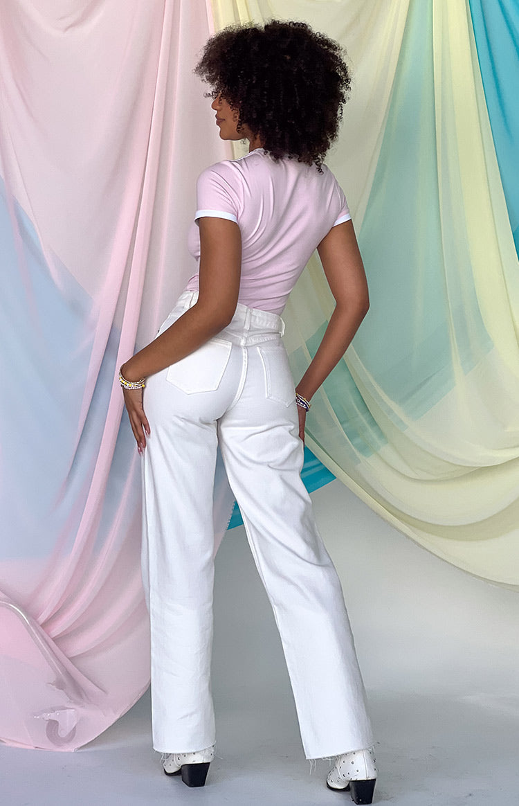 Rear view of white high-waisted wide-leg denim jeans showing the back pockets and a frayed raw hem