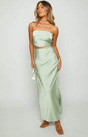 Full length view of the sage green satin maxi skirt, highlighting its flowing silhouette and subtle side slit