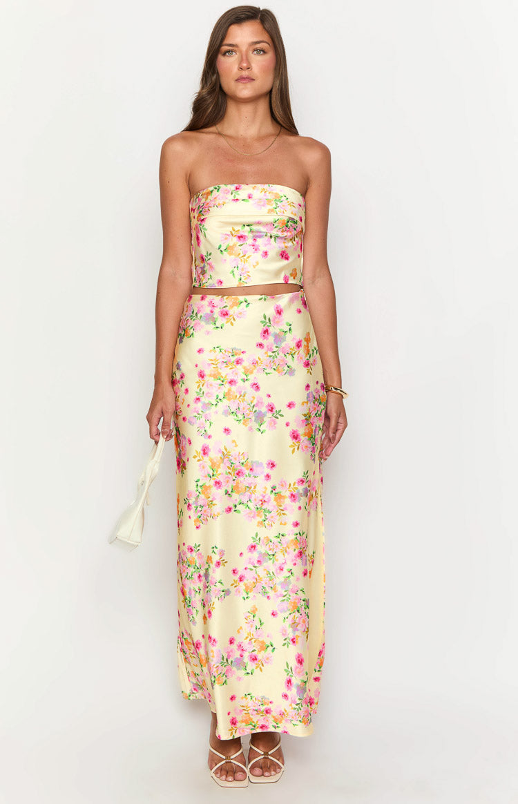 Yellow satin maxi skirt with a dense floral pattern in shades of pink, orange, and purple