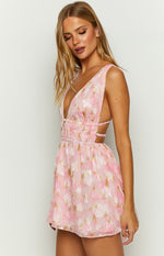 Side view of a pink floral chiffon mini dress with a deep V-neck, shirred waist, and side cutouts with thin straps