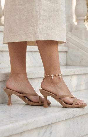 Side view of camel suede kitten heels with thin criss-cross straps and a flared heel