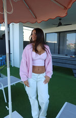Light pink crop top with a crossover sweetheart neckline and ruched bust detail