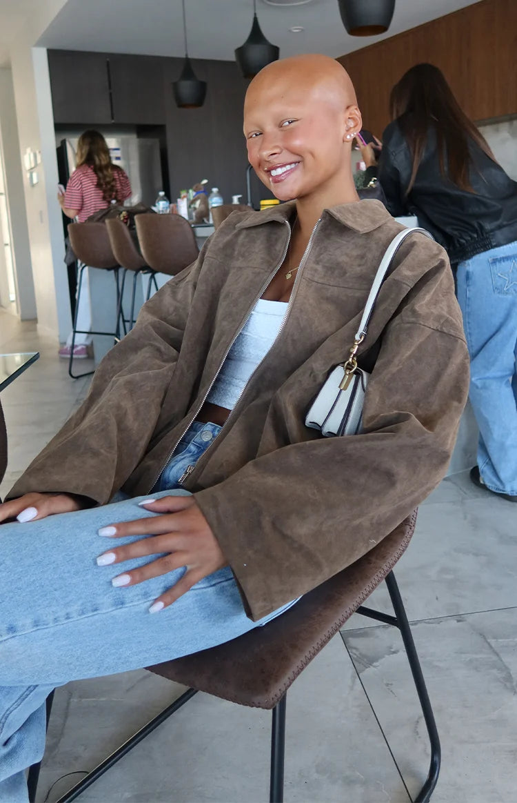 Front view of a brown suedette bomber jacket with a wide collar and open zipper, showing its relaxed fit