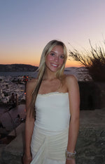 Cream strapless mesh maxi dress with a ruffled neckline and ruched, draped skirt detail