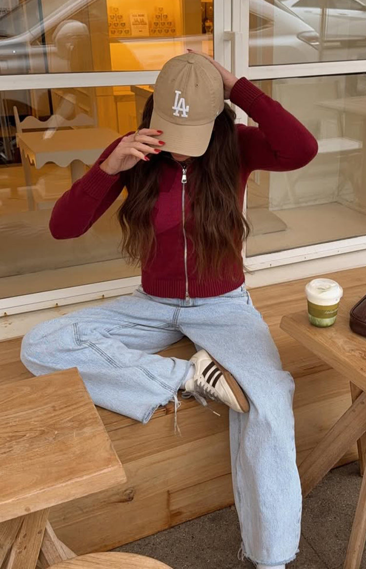 Burgundy zip-up knit sweater with a silver zipper, ribbed cuffs, and a fitted, cropped silhouette