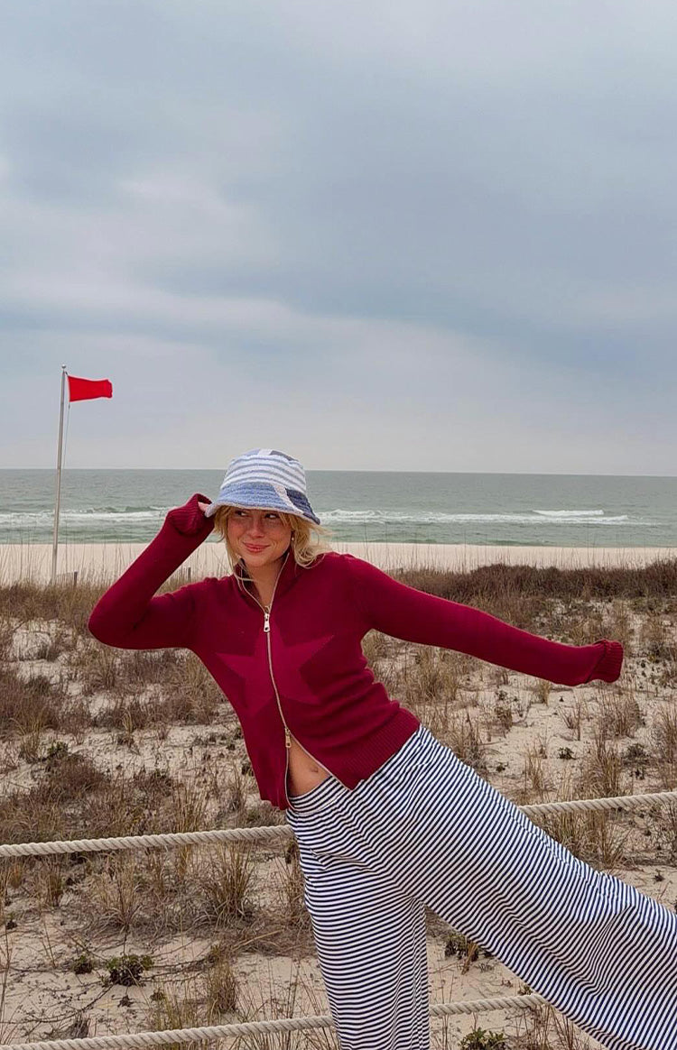Burgundy knit zip-up sweater with a large star graphic, ribbed hem and cuffs
