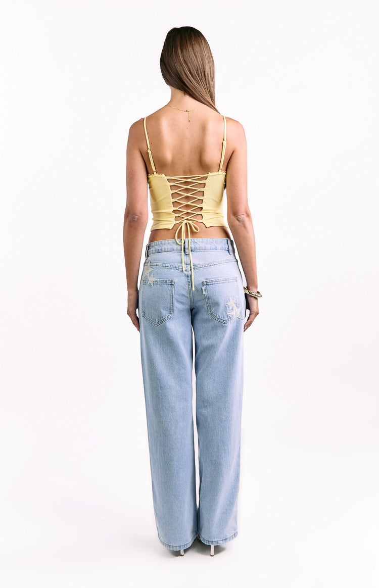 Rear view of a yellow corset top with a lace-up back detail and thin spaghetti straps