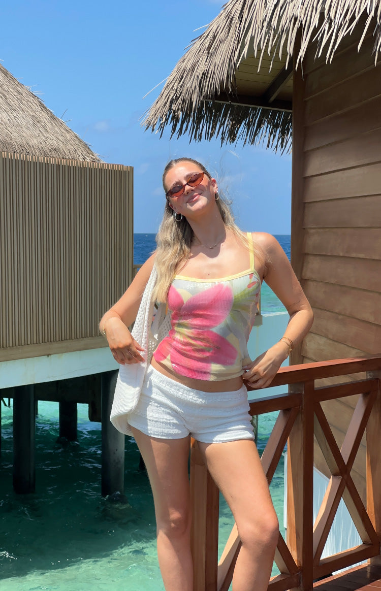Front view of a yellow floral sequin tank top with thin straps and a fitted, cropped silhouette