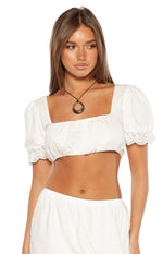 White cotton crop top with a square neckline and short puff sleeves featuring broderie trim