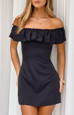 Black mini dress with white polka dots and a wide ruffled elasticated off-shoulder neckline
