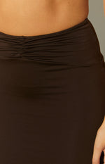 Close-up of the ruched waist detail on a chocolate brown maxi skirt