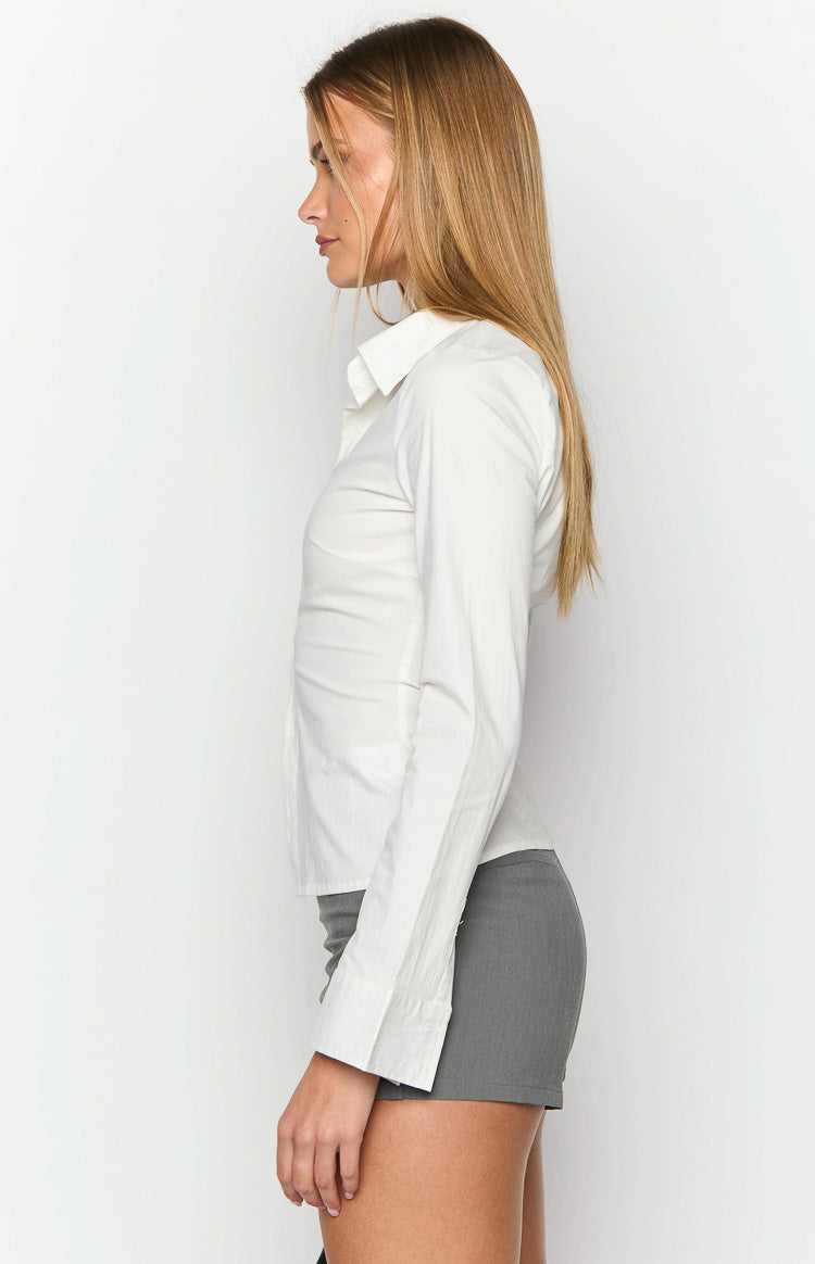 Back view of a white fitted long sleeve shirt with vertical tailored seams and wide buttoned cuffs