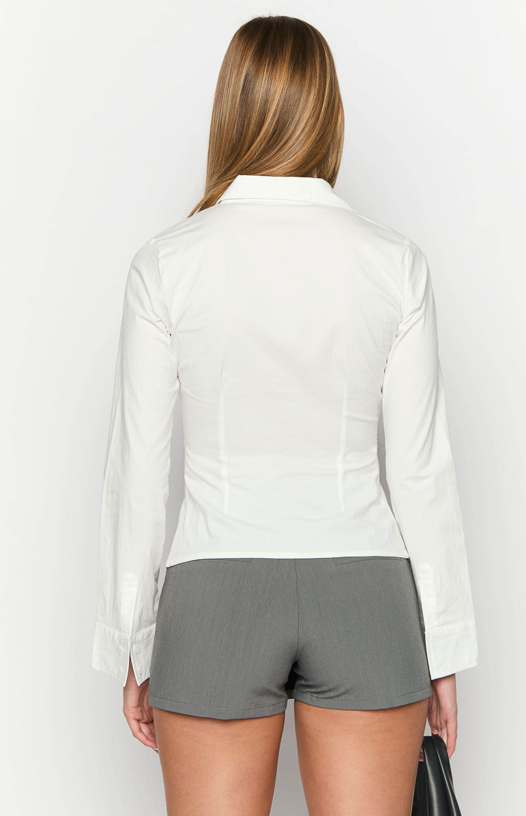 Close-up of the open collar, white buttons, and fitted bodice of a white long sleeve shirt