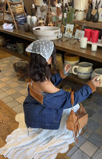 Rear view of an oversized mid wash denim jacket with brown cord trim on the cuffs and collar