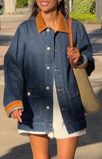 Front view of an oversized mid-wash denim jacket with tan corduroy collar and cuffs, white buttons, and patch pockets