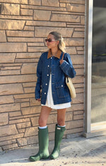 Side view of a mid-wash denim oversized jacket with a brown corduroy collar and white button-front closure