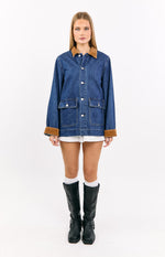 Front view of a mid wash denim oversized jacket with a brown corduroy collar and cuffs, and large patch pockets