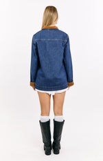 Rear view of a mid wash blue denim oversized jacket with a brown corduroy collar and cuffs