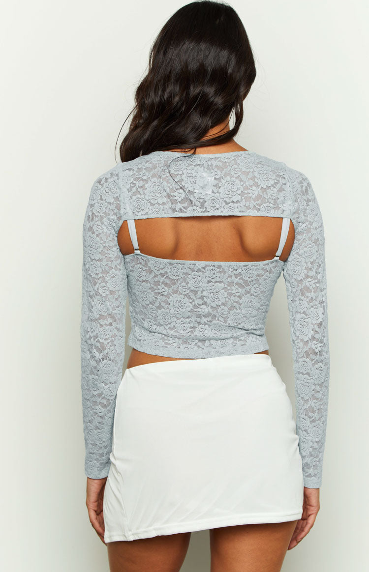 Rear view of the blue lace long sleeve shrug with an open back, revealing the matching lace cami underneath