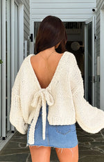 Rear view of a cream chunky knit cardigan with a tie-up open back and long voluminous sleeves