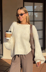 Rear view of a cream knit cardigan with a tie-up back detail and relaxed long sleeves